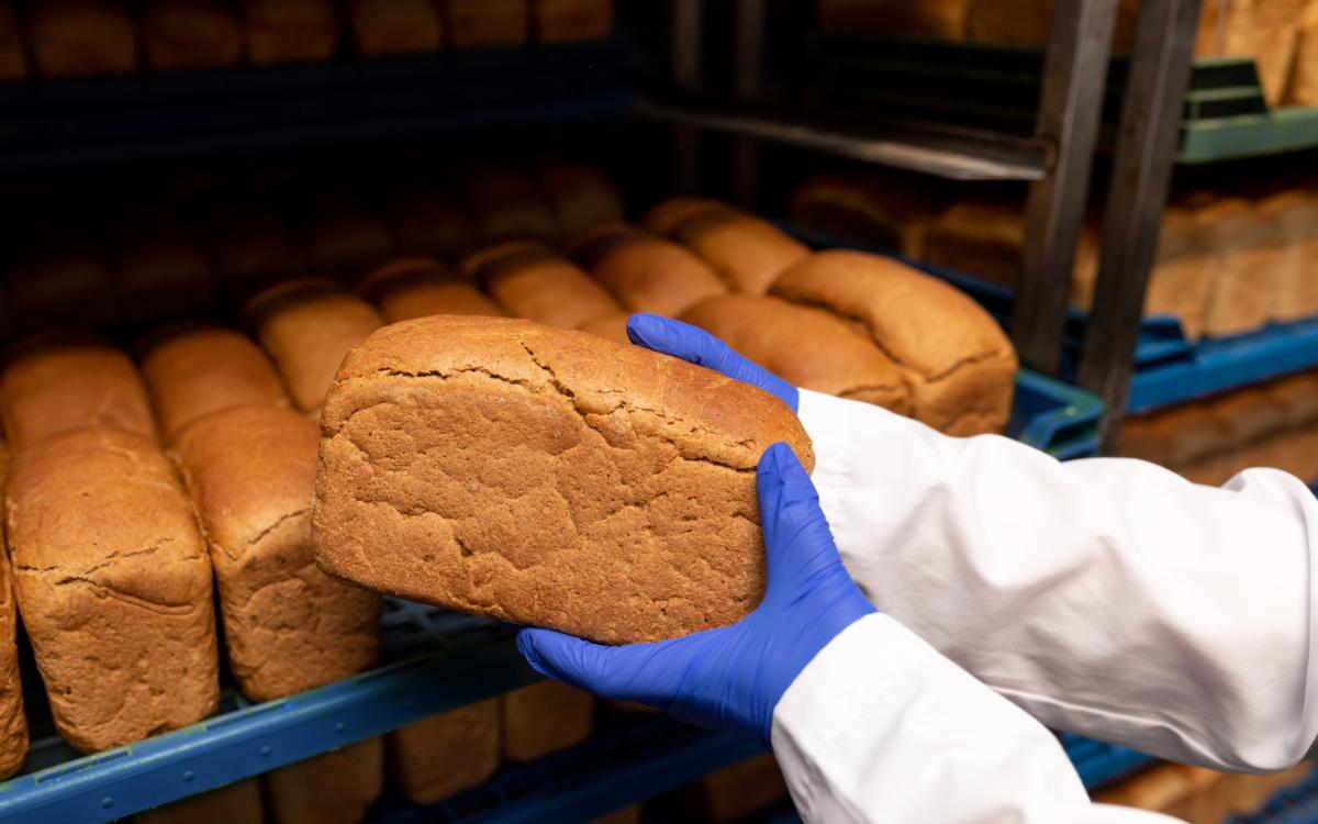 How do bakery staff maintain hand hygiene at an automatic hand washing station?